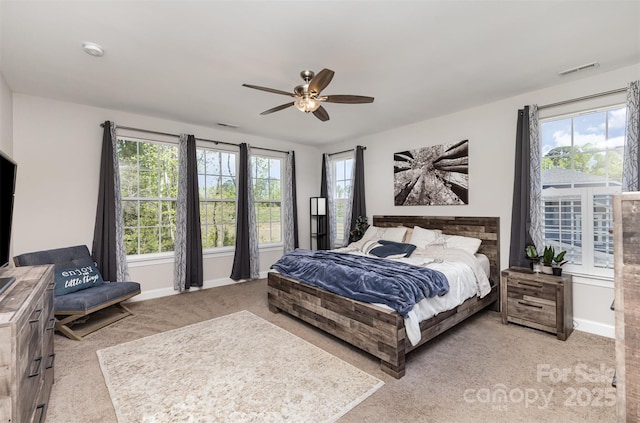 bedroom featuring carpet floors, multiple windows, visible vents, and baseboards