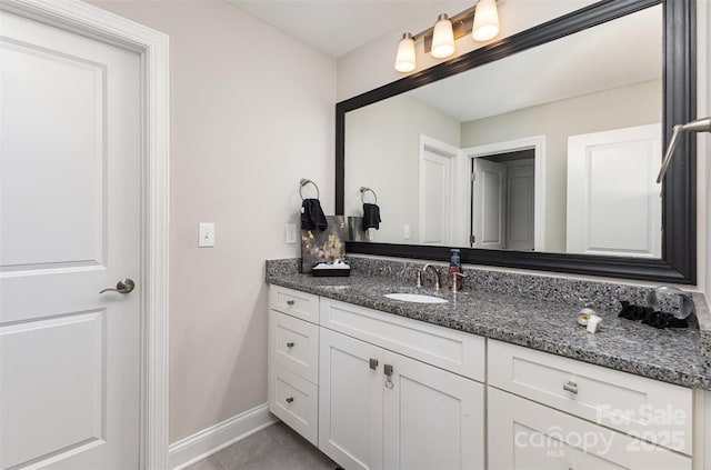 bathroom with baseboards, vanity, and tile patterned floors