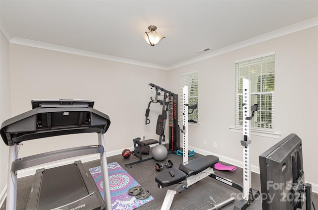 exercise room with visible vents, crown molding, and baseboards