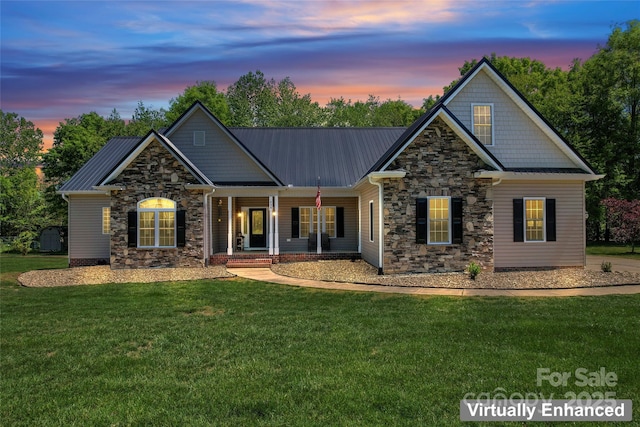 craftsman-style home with stone siding, a porch, a front lawn, and metal roof
