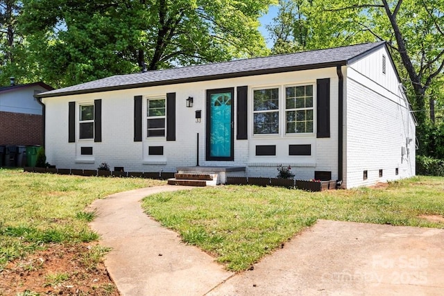 view of front of house with crawl space, a front lawn, and brick siding