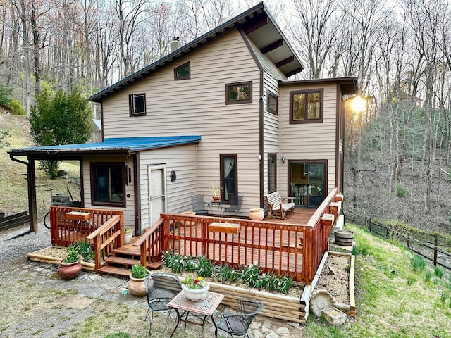 rear view of property with fence and a wooden deck