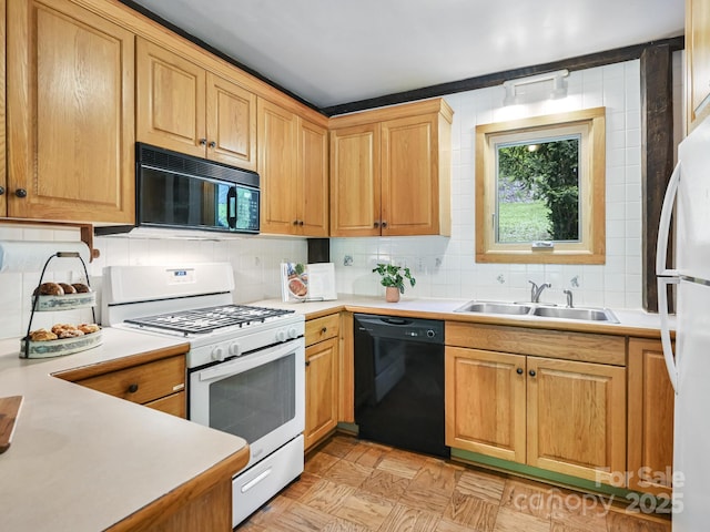 kitchen with a sink, backsplash, black appliances, and light countertops