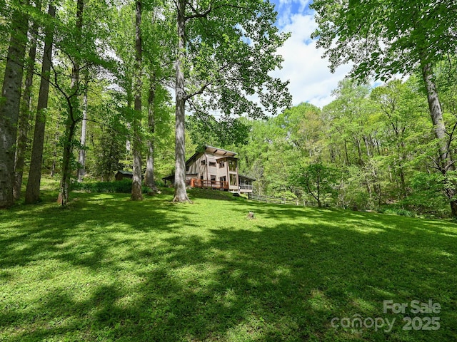 view of yard with a deck and a wooded view