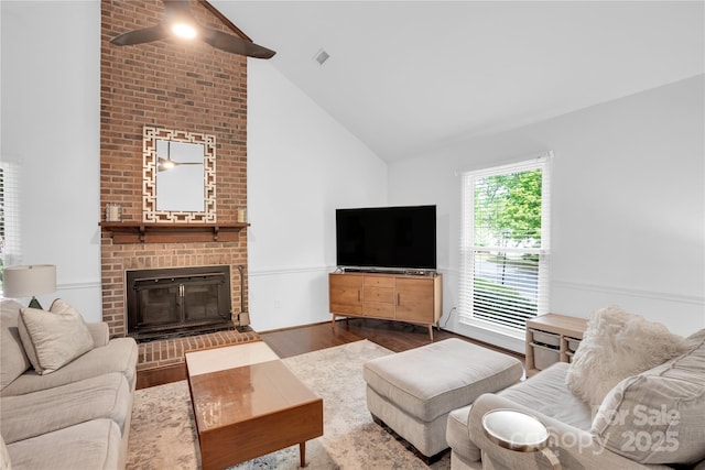 living area with visible vents, dark wood-style floors, a fireplace, and high vaulted ceiling