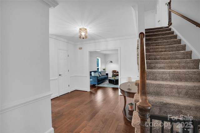 interior space featuring crown molding, hardwood / wood-style floors, and stairway