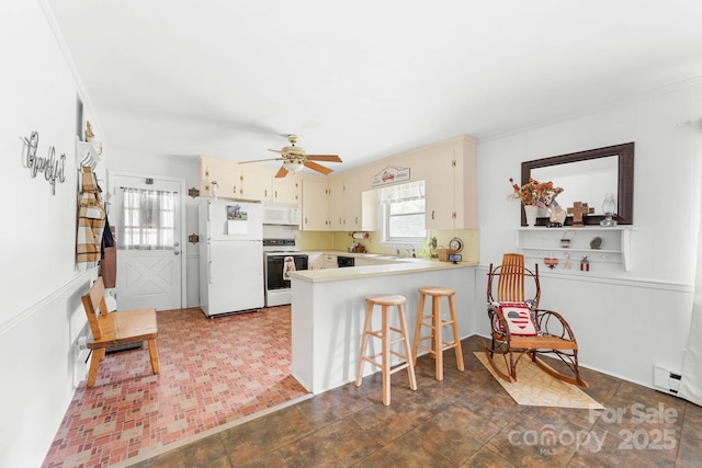 1307 Armstrong Rd, Belmont, NC 28012 - kitchen featuring white appliances, a peninsula, a sink, light countertops, and cream cabinets