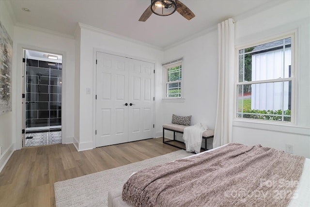 2138 Revolution Park Dr, Charlotte, NC 28208 - bedroom with ornamental molding, wood finished floors, a closet, and a ceiling fan