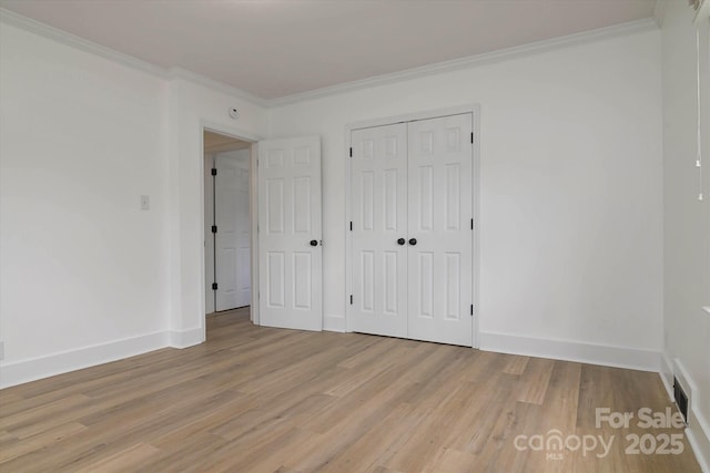 2138 Revolution Park Dr, Charlotte, NC 28208 - unfurnished bedroom with crown molding, light wood-style floors, and a closet