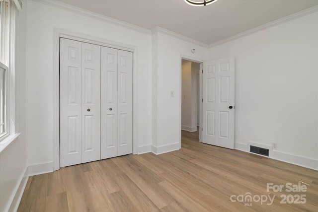 2138 Revolution Park Dr, Charlotte, NC 28208 - unfurnished bedroom with ornamental molding, light wood-type flooring, and a closet