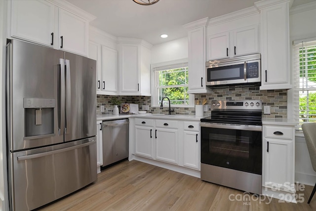 2138 Revolution Park Dr, Charlotte, NC 28208 - kitchen featuring stainless steel appliances, light countertops, white cabinets, healthy amount of natural light, and recessed lighting