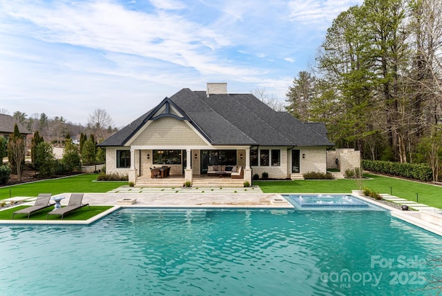 pool with an outdoor living space, a lawn, a deck, and an in ground hot tub