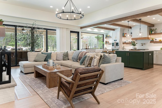 living area with an inviting chandelier, a healthy amount of sunlight, light wood finished floors, and recessed lighting