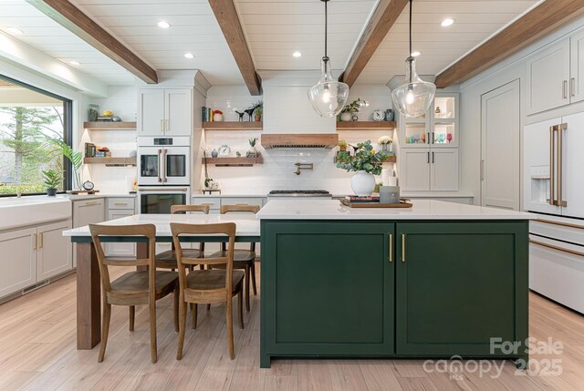 kitchen with open shelves, double oven, green cabinets, and white cabinetry