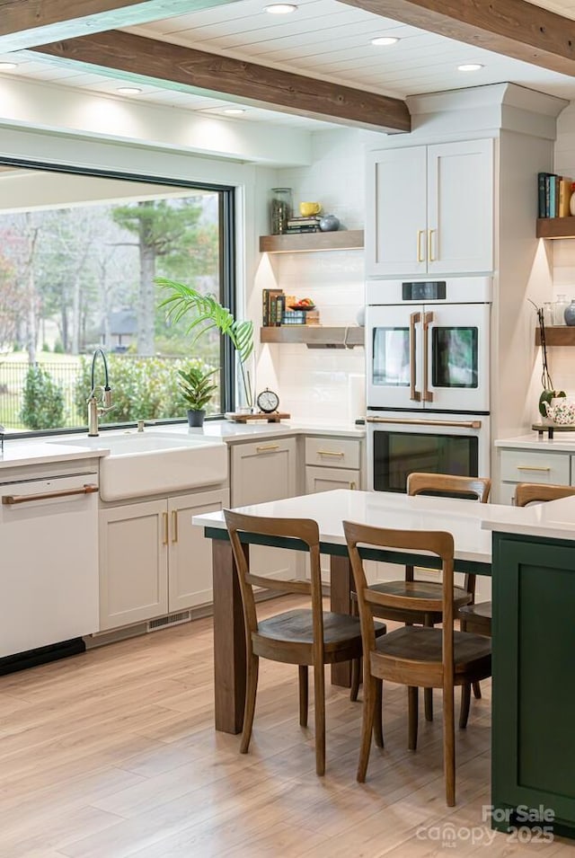 kitchen featuring recessed lighting, open shelves, light countertops, white appliances, and beam ceiling
