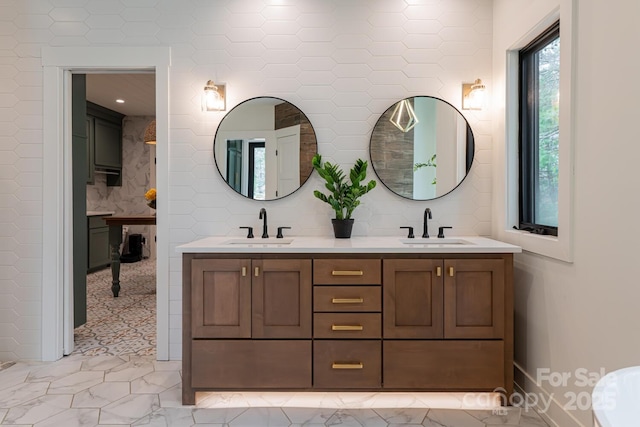 bathroom with decorative backsplash, marble finish floor, a sink, and double vanity