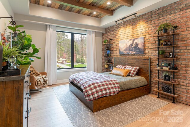 bedroom with brick wall, wooden ceiling, beamed ceiling, and light wood-style flooring