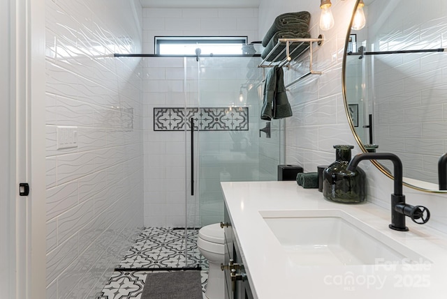bathroom with vanity, a shower stall, and toilet
