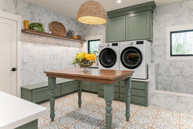 washroom featuring a healthy amount of sunlight, independent washer and dryer, light tile patterned floors, and cabinet space