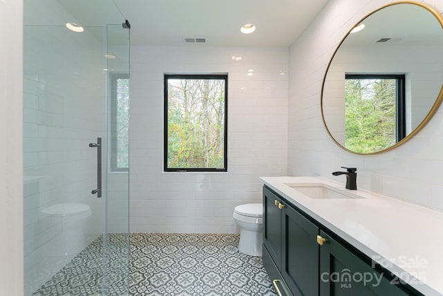 bathroom featuring a shower stall, vanity, tile walls, toilet, and visible vents