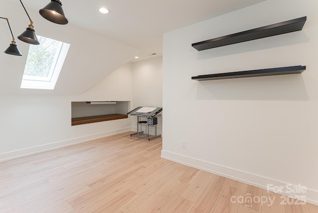 bonus room with baseboards, vaulted ceiling with skylight, wood finished floors, and recessed lighting