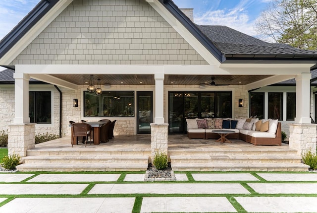 back of property featuring outdoor lounge area, stone siding, outdoor dining area, roof with shingles, and ceiling fan