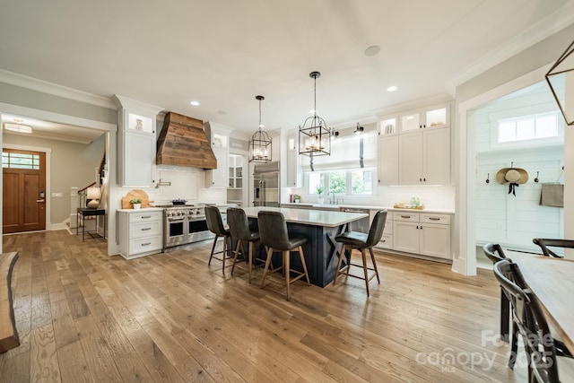 365 Delburg St, Davidson, NC 28036 - kitchen with high end appliances, premium range hood, ornamental molding, tasteful backsplash, and white cabinets