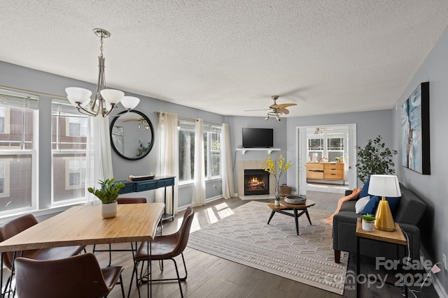 1201 Deermouse Way, Hendersonville, NC 28792 - dining area with a tile fireplace, hardwood / wood-style floors, a textured ceiling, and ceiling fan with notable chandelier