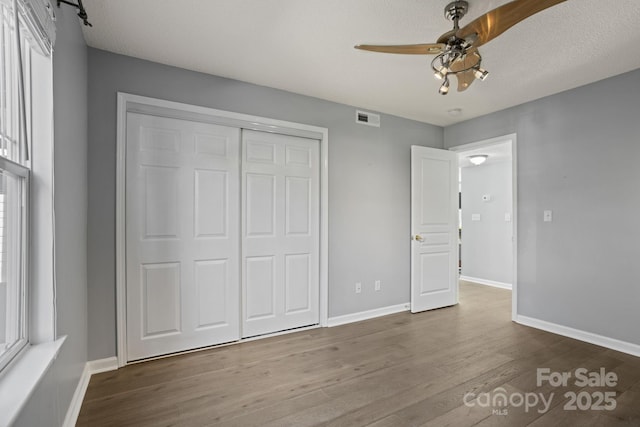 1201 Deermouse Way, Hendersonville, NC 28792 - unfurnished bedroom with a closet, wood finished floors, visible vents, and baseboards