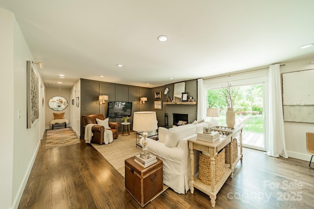 living area featuring baseboards, a fireplace, recessed lighting, and dark wood-style flooring