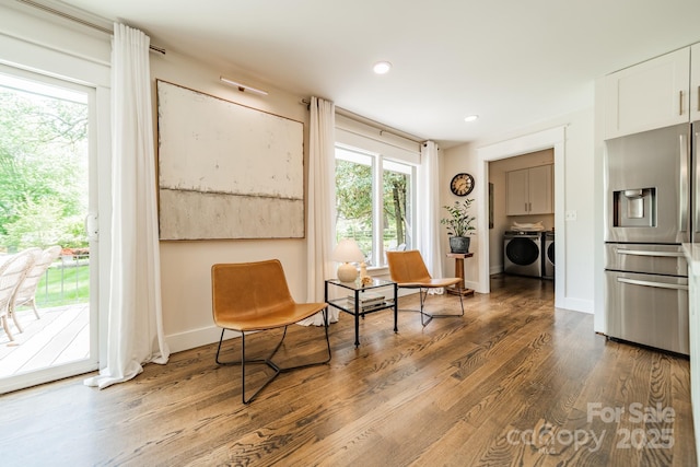 living area featuring washing machine and dryer, baseboards, wood finished floors, and recessed lighting