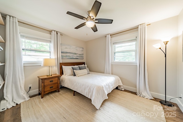 bedroom featuring wood finished floors, a ceiling fan, and baseboards