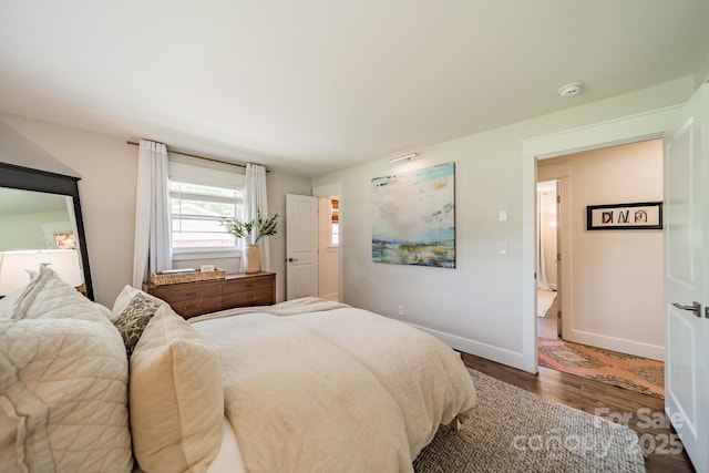 bedroom featuring wood finished floors and baseboards