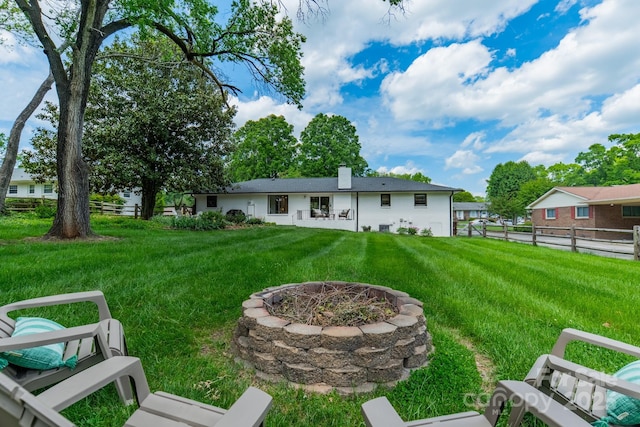 view of yard featuring a fire pit and fence