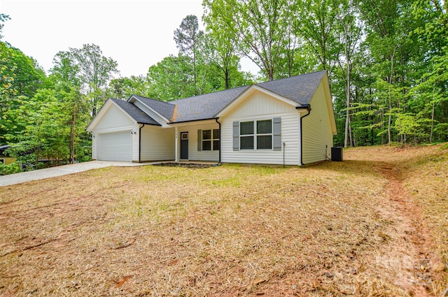 single story home with a shingled roof, an attached garage, a front yard, central air condition unit, and driveway