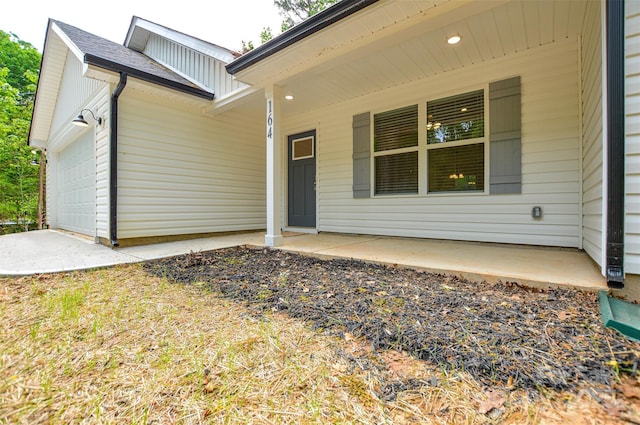 property entrance with covered porch and a garage