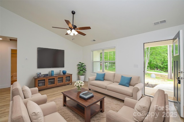 living room featuring light wood-style floors, ceiling fan, vaulted ceiling, and visible vents