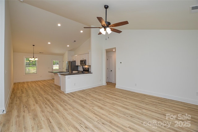 unfurnished living room featuring light wood finished floors, high vaulted ceiling, ceiling fan with notable chandelier, recessed lighting, and baseboards
