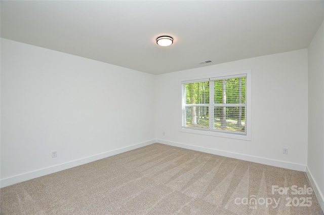 spare room with baseboards, visible vents, and carpet