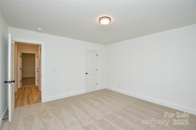 spare room featuring baseboards and carpet flooring