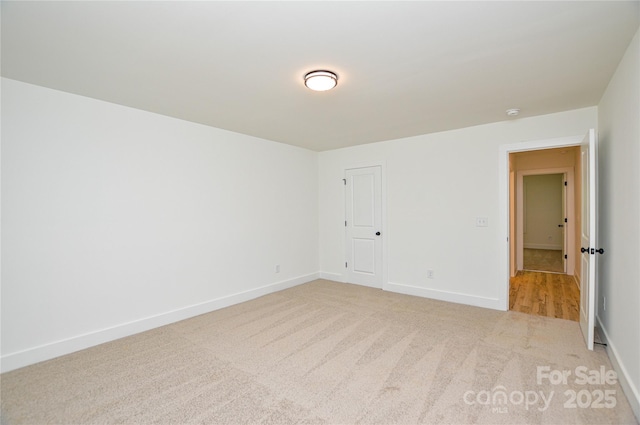 unfurnished room featuring baseboards and carpet