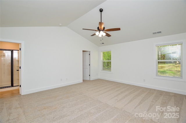 spare room with visible vents, lofted ceiling, carpet flooring, baseboards, and a ceiling fan