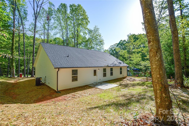 back of house featuring roof with shingles and central AC