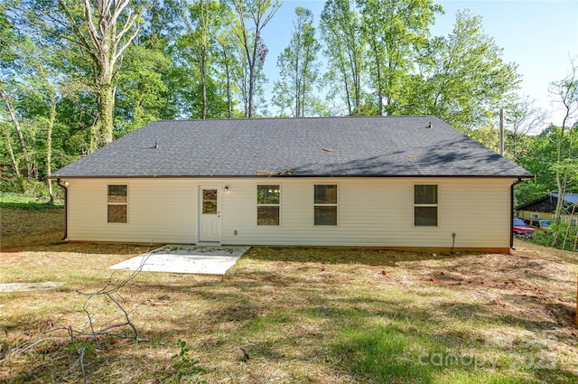 rear view of property with a shingled roof and a patio area