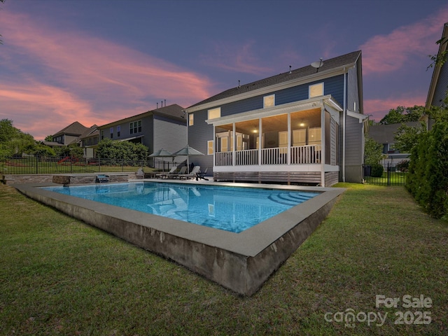 3057 Drummond Ave, Indian Land, SC 29707 - pool at dusk featuring a sunroom, a fenced backyard, a lawn, and a fenced in pool