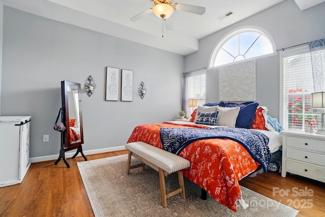 bedroom with visible vents, ceiling fan, and wood finished floors