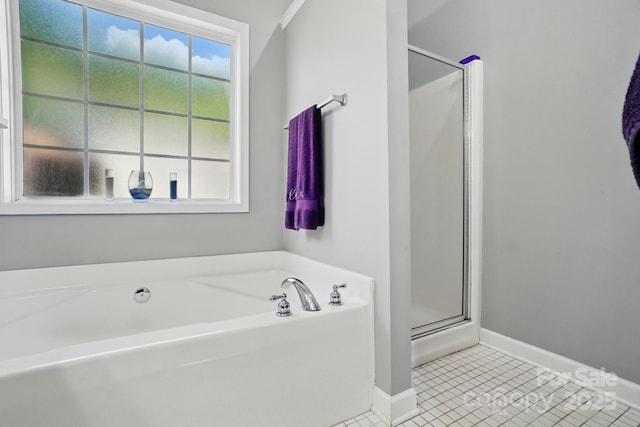 bathroom featuring baseboards, tile patterned floors, a bath, and a stall shower