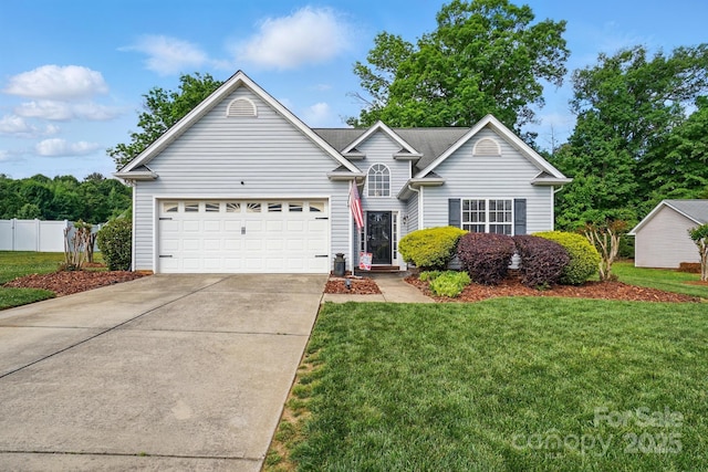 view of front of property with concrete driveway, fence, a front yard, and a garage