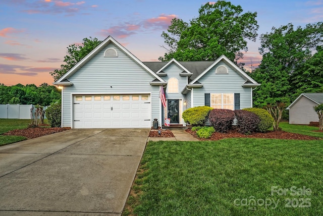 view of front of property with an attached garage, fence, a front yard, and concrete driveway