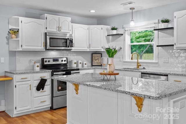 4009 Dunwoody Dr, Charlotte, NC 28215 - kitchen with stainless steel appliances, a sink, open shelves, white cabinets, and recessed lighting